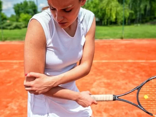 Donna gioca a tennis e si tocca il gomito a causa di un dolore